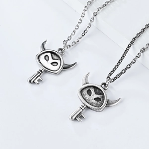 Detailed view of vintage silver devil horn key pendant with retro distressed finish