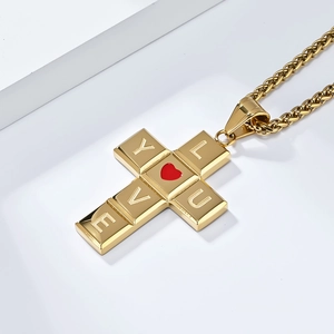Détail du pendentif croix en acier doré avec cœur rouge et gravure I LOVE YOU