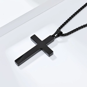 Detailed close-up of a minimalist black stainless steel cross pendant on a beaded chain