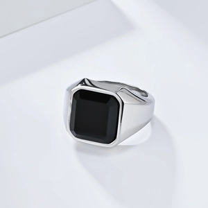 Detalle macro de anillo para hombre en acero plateado con una gran piedra negra rectangular