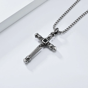 Detail of vintage gothic cross pendant with black gemstone and skull motifs