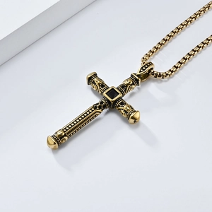 Macro detail of vintage gold cross pendant with black gemstone and skull relief