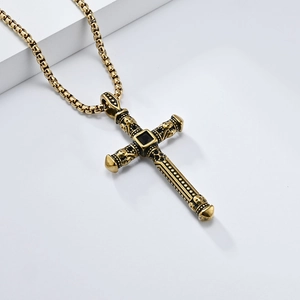 Vintage stainless steel cross necklace with skull carving and black stone on white stand