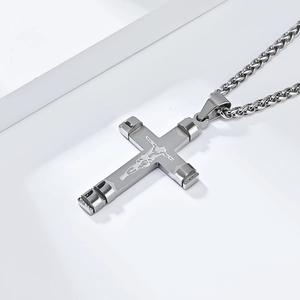 Macro d'un pendentif crucifix en acier inoxydable poli avec détail de Jésus en relief