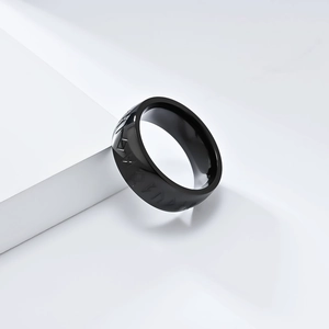 Macro shot of black stainless steel Viking rune ring on a minimalist white platform