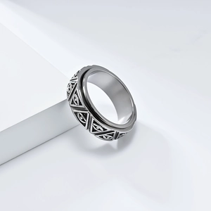 Macro detail of rotating stainless steel fidget ring with etched Eye of Horus and pyramids