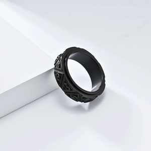 Detailed macro of black stainless steel spinner ring with triangle relief patterns