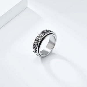 Macro detail of rotating stainless steel Eye of Horus ring with engraved pyramid patterns