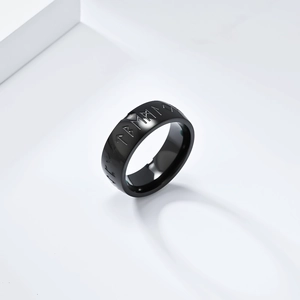 Macro shot of polished black stainless steel ring with Nordic Viking rune engravings