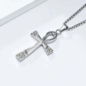 Détail du pendentif croix Ankh avec strass brillants sur une chaîne à mailles carrées