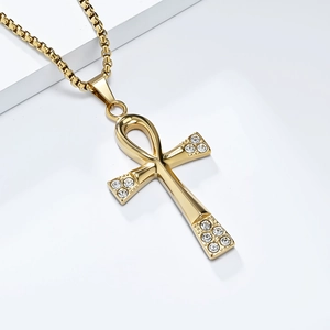 Vue détaillée d'un pendentif croix d'Ankh dorée avec cristaux et chaîne box