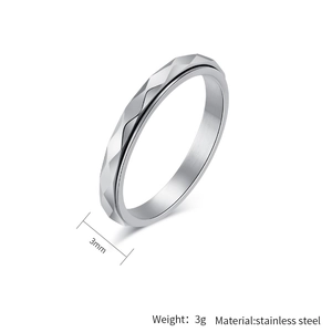 Macro shot of 3mm wide spinner ring with geometric diamond-cut edges in stainless steel
