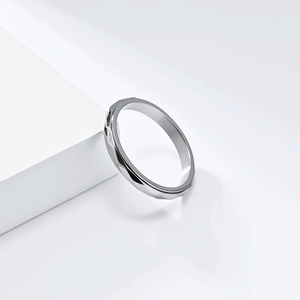 Detail showing geometric diamond-cut faceted spinning ring on white display stand