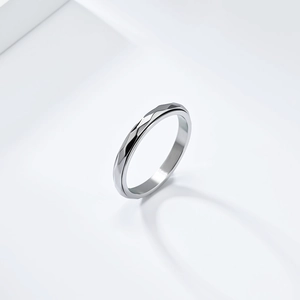 Polished silver stainless steel spinner ring with geometric diamond-cut texture surface