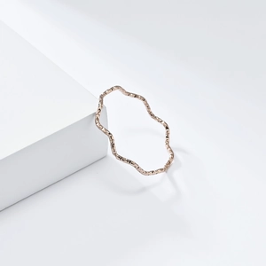 Rose gold 1mm wavy titanium steel ring with hammered texture on white geometric block