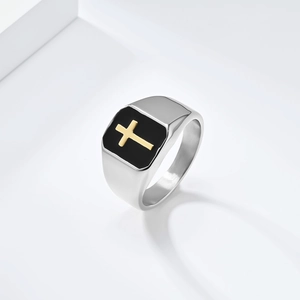 Detail of cross signet ring featuring black enamel inlay and gold cross on silver band