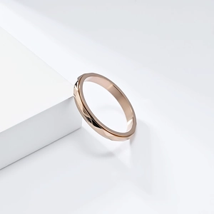 Macro shot of rose gold geometric ring with textured facets on a white minimalist pedestal