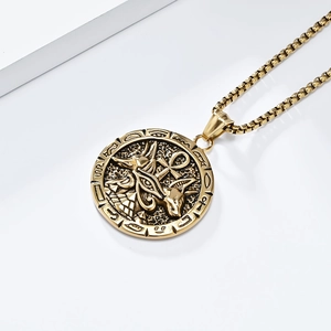Macro view of Egyptian Ankh cross and Anubis relief on a golden stainless steel pendant