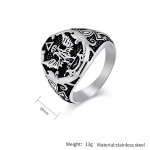 Macro shot of silver and black stainless steel ring showing double-headed eagle and carving
