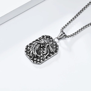 Macro view of vintage dragon head pendant in black aged stainless steel on box chain
