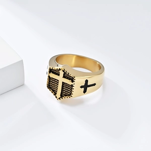 Detailed macro view of a men's gold signet ring featuring a 3D cross on a black wavy base