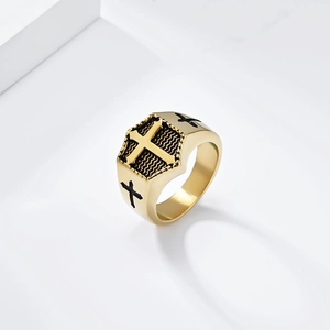 Macro detail of men's gold stainless steel cross shield ring with black textured inlay
