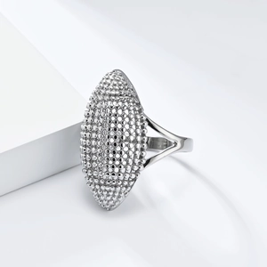 Elegante anillo ovalado plateado con textura de cuentas sobre un soporte blanco geométrico