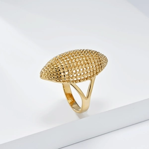 Detalle de anillo de titanio dorado con gran cara ovalada calada y banda de estilo dividido