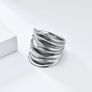 Makroaufnahme eines silbernen Rings mit Wellentextur und poliertem Mehrschichtdesign