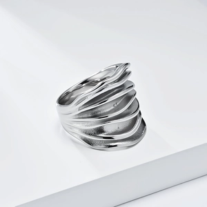 Eleganter Ring aus poliertem Edelstahl mit geschichteter Wellenstruktur auf weißem Hintergrund