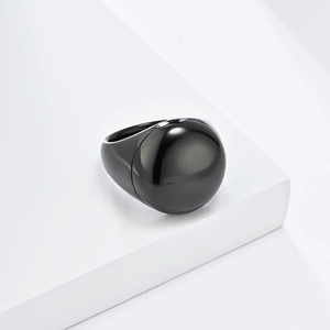 Dettaglio macro dell'anello a cupola in titanio nero lucido su un supporto geometrico