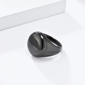 Dettaglio dell'anello in titanio nero lucido con superficie curva liscia e brillante
