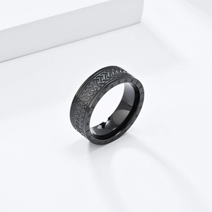 Macro shot of black stainless steel ring with Celtic knot reliefs and Nordic runes