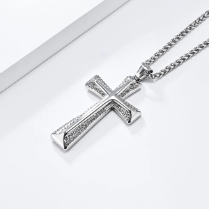 Vue macro du pendentif croix hip hop argenté avec zircons sur une chaîne cubaine