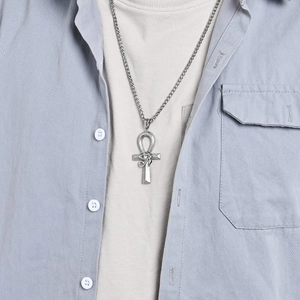 Collana con croce Ankh d'argento e pendente occhio di Horus indossata da un modello uomo