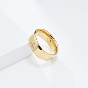 Primer plano del anillo masónico de tungsteno dorado con grabado de escuadra y compás