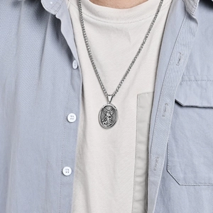 Vintage St. Michael Archangel shield pendant necklace on model with blue denim shirt