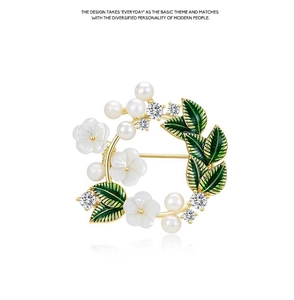 Detailed view of gardenia wreath brooch with pearls, green enamel leaves and zircon gems