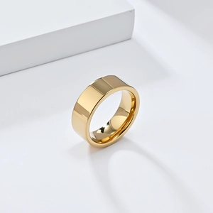 Vue détaillée d'une bague large en tungstène doré avec finition polie sur socle blanc