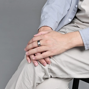 Minimalist brushed tungsten carbide ring for men and women worn on a hand in a close-up shot