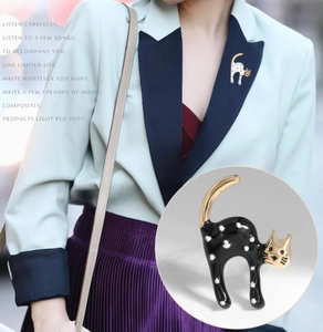 Detailed view of cute cat brooches with black and white polka dots on a blazer