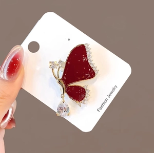 Elegant gold butterfly brooch with red enamel and sparkling diamonds, accessory for coats