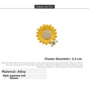 Détail de la broche tournesol en émail avec centre en cristal et petite abeille