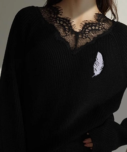 Detail of silver feather brooch with pavé rhinestones pinned on a black garment