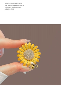 Gros plan détaillé d'une broche marguerite en émail jaune avec strass blancs et abeille perlée