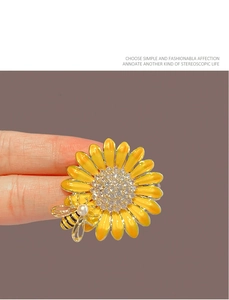 Détail du broche tournesol en émail avec cristaux étincelants et accent d'abeille perlée