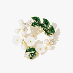 Elegant gold flower wreath brooch with white gardenia flowers, pearls and green leaves