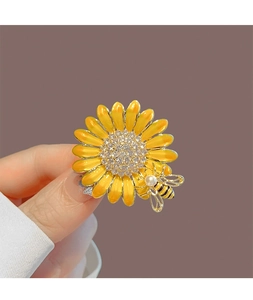 Détail de la broche tournesol avec pétales en émail jaune, cœur cristal et abeille