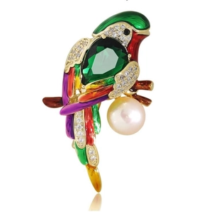 Detailed close-up of a luxury enamel parrot brooch with green emerald and large pearl