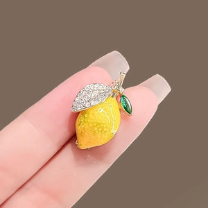 Gros plan détaillé d'une broche citron jaune avec cristaux brillants et touche de vert